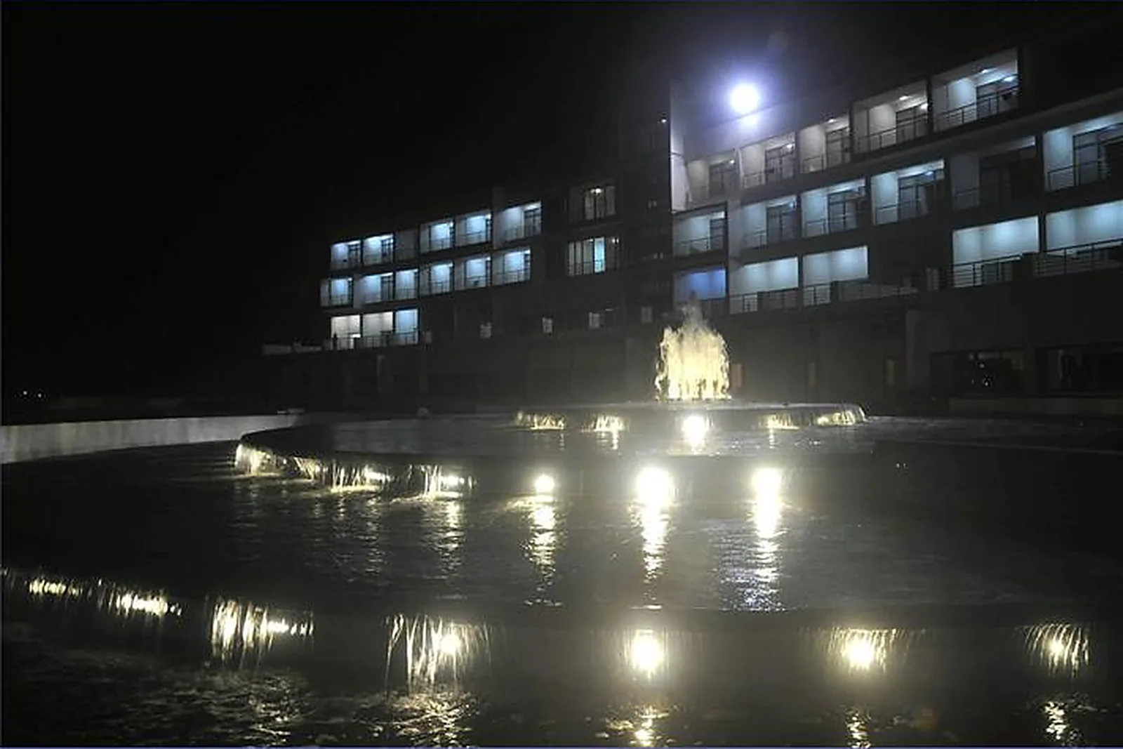 Sagar Darshan Guest House at night, its windows lit and the fountain in the forecourt illuminated