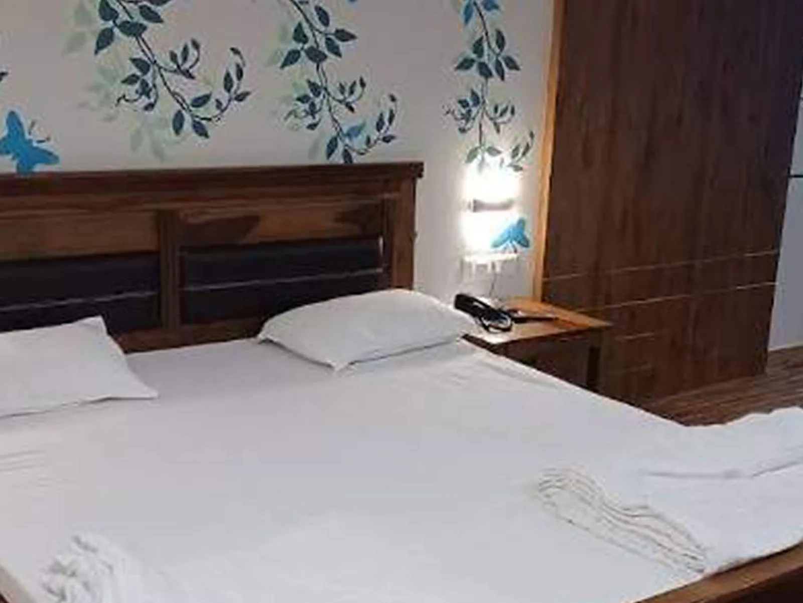 Premier Room with a double bed, a wooden headboard, a patterned wall and a window