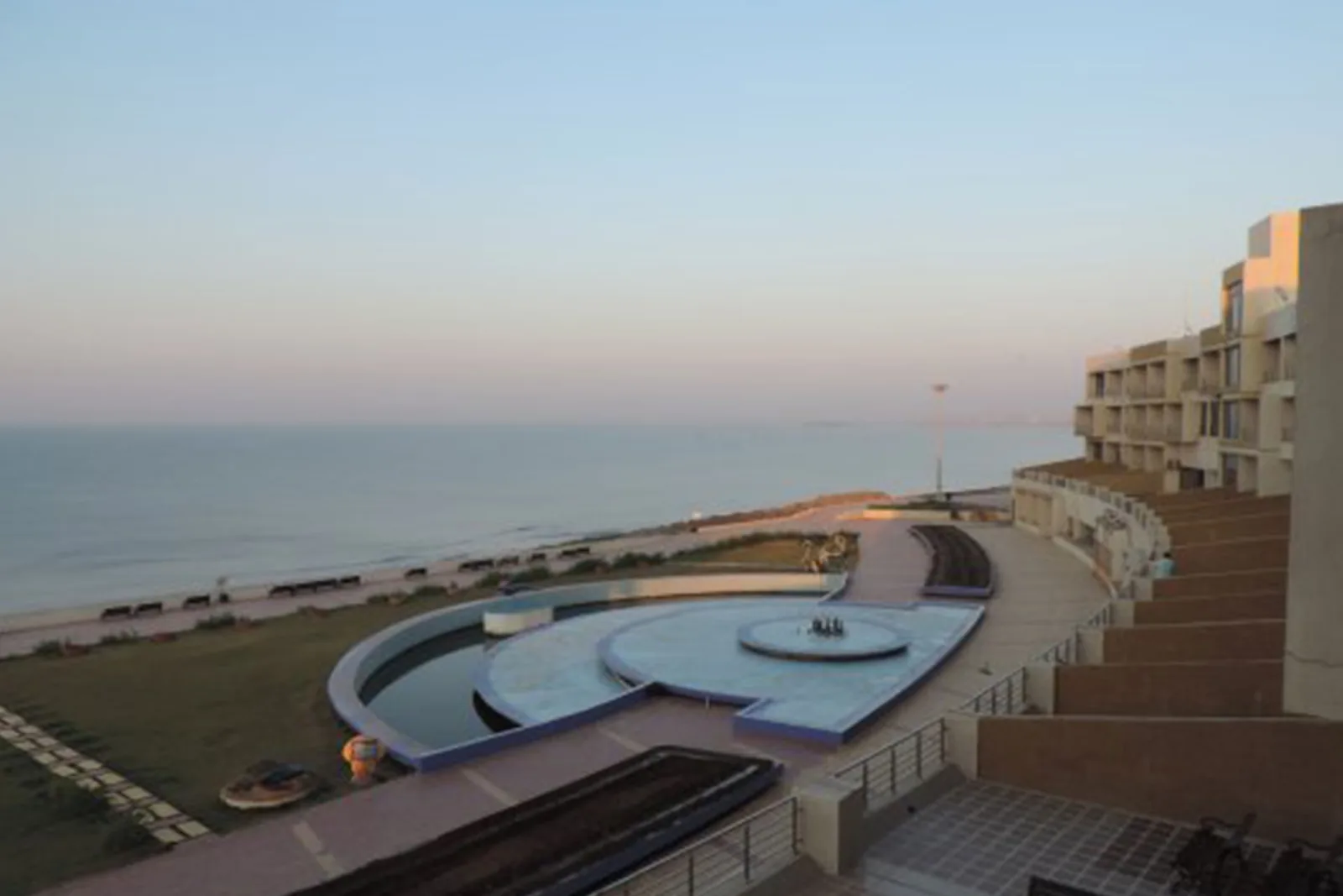 The circular water feature in the guest house forecourt with the open sea behind it