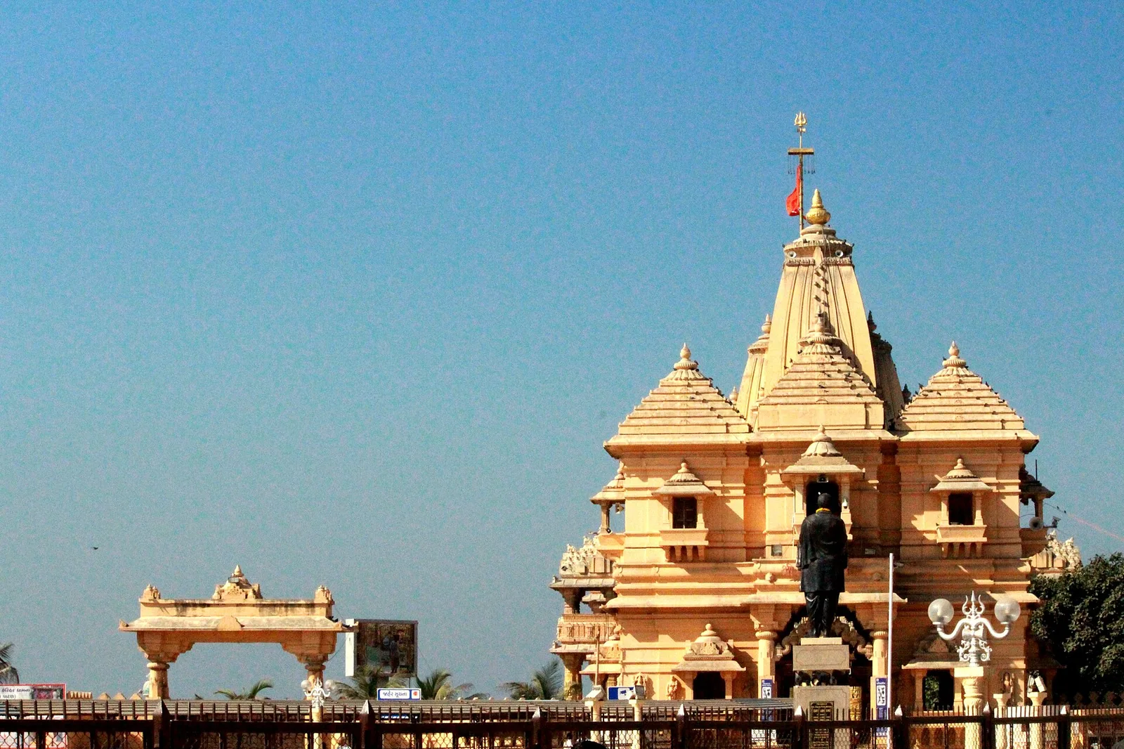 The carved shikhara and flag of Somnath temple, Gujarat, against a clear blue sky